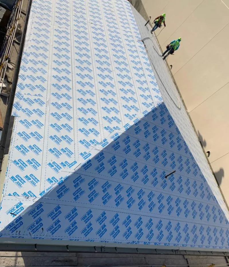 Professional roofers installing underlayment on a metal roof in Leonia